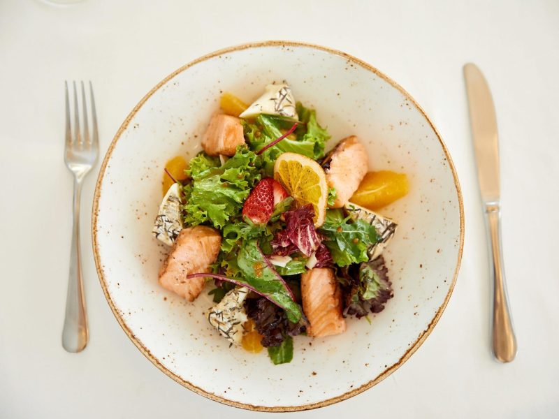Topview of a served pork salad with cheese and lettuce Opciones de menú flexibles | Wink Eventos